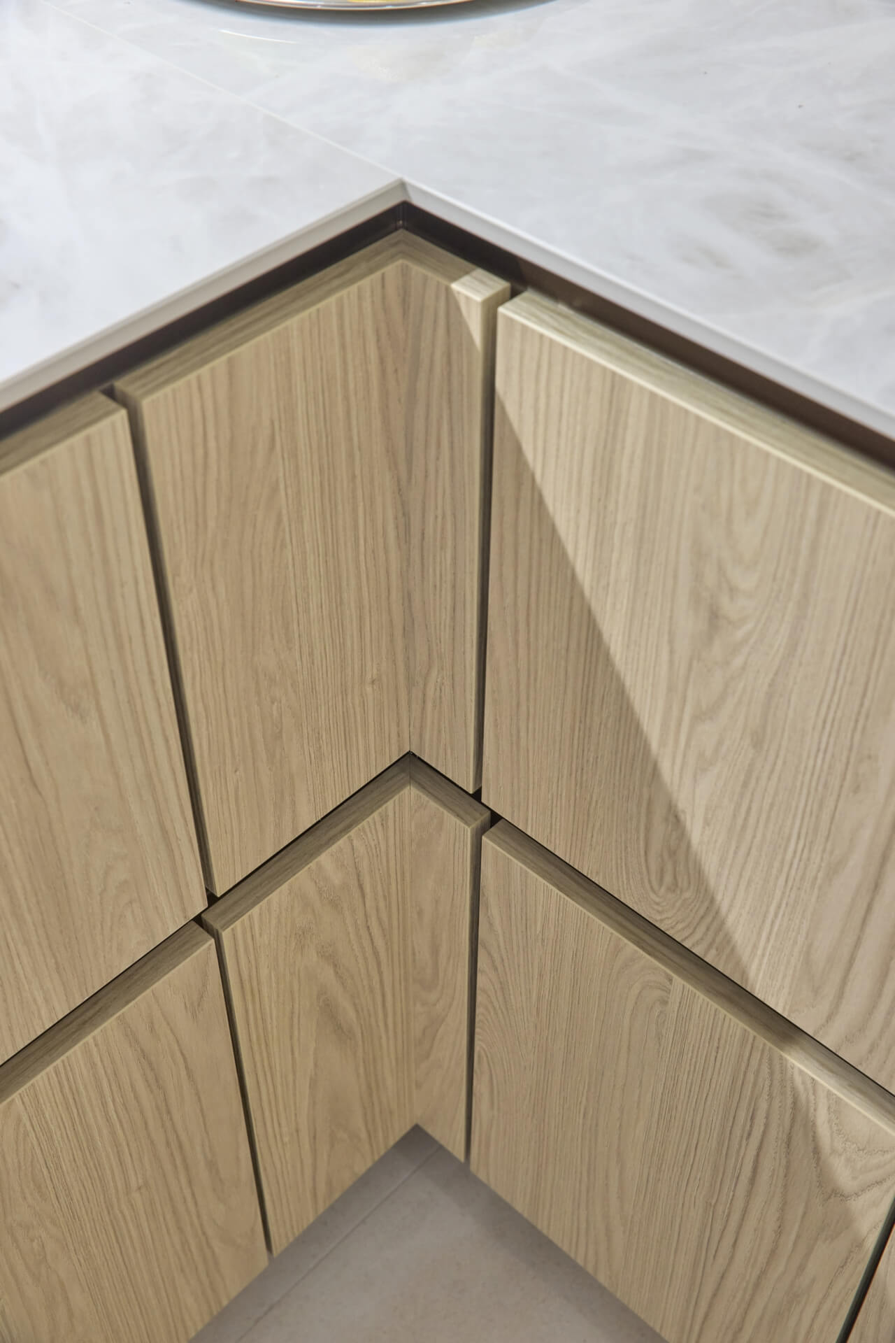 Kaksiosaiset kulmatäytteet alakaappien kulmissa viimeistelevät keittiön ilmeen.